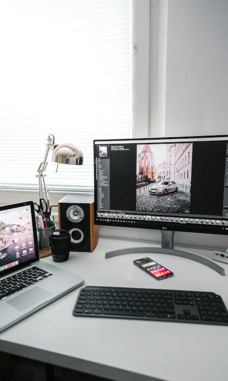 Fotografía de tres computadoras en un escritorio.